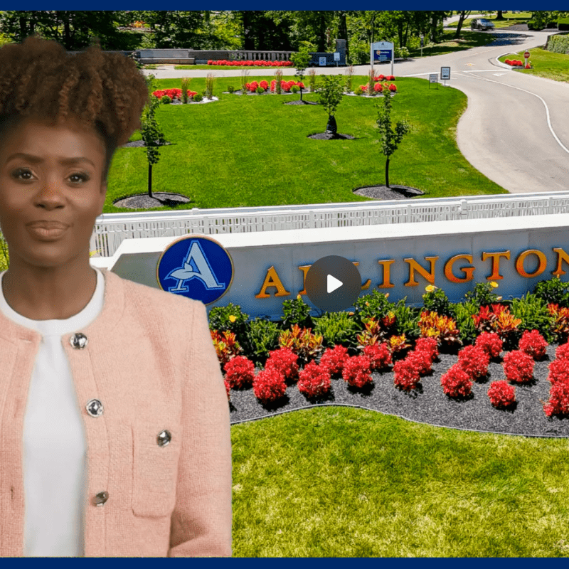 When a loved one passes at home blog video thumbnail with a woman wearing a pink jacket standing in front of the Arlington Memorial Gardens main entrance